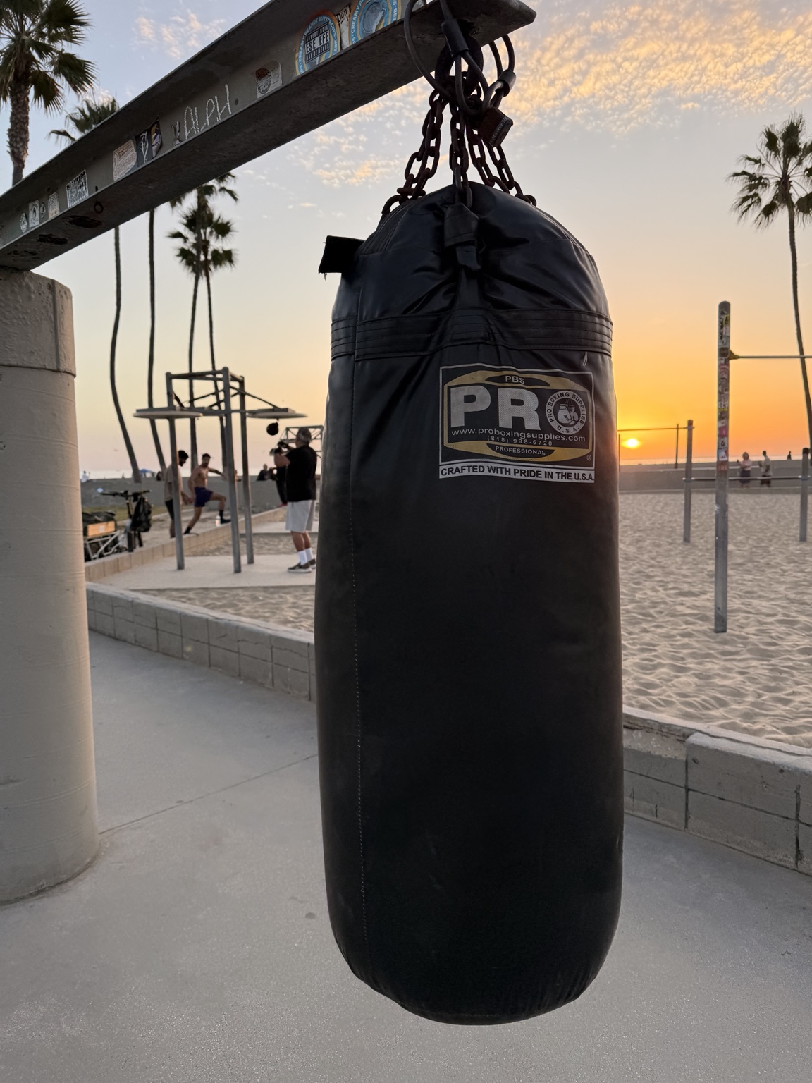 A heavy bag hanging at Muscle Beach during sunset